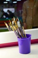 Art paint brushes in cup are located in the children's entertainment hall at the mirror photo