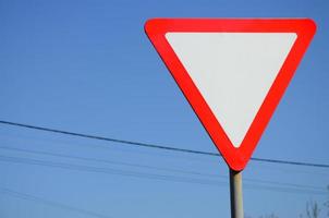 Traffic sign in the form of a white triangle. Give way photo