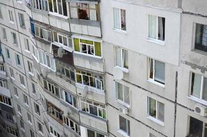 Facade of a grey multi storey soviet panel building. Russian old urban residential houses with windows and balcony. Russian neighborhood photo