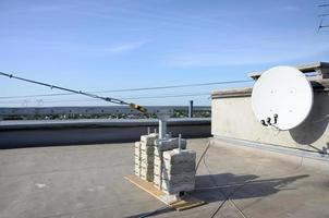 Counter weight or weight balance concrete blocks or bricks as part of suspended wire rope platform for facade works on high multistorey buildings. Many blocks with metal handles photo