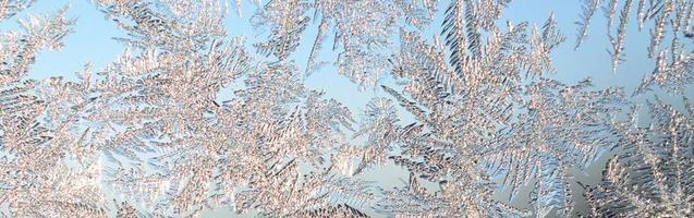 Snowflakes frost rime macro on window glass pane photo