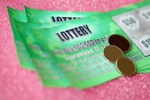 Close up view of green lottery scratch cards. Many used fake instant lottery tickets with gambling results. Gambling addiction photo