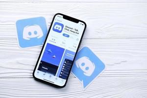 KHARKOV, UKRAINE - MARCH 5, 2021 Discord icon and application from App store on iPhone 12 pro display screen on white table photo