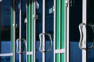 Chrome door handle and glass of modern aluminium office facade photo