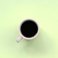 pequeña taza de café con leche sobre fondo de textura de papel de color lima pastel de moda foto