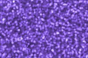 Blurred violet decorative sequins. Background image with shiny bokeh lights from small elements photo