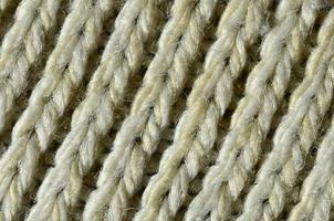 Fabric texture of a soft yellow knitted sweater. Macro image of the structure of bindings in yarns photo