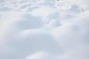 Fragment of the road, covered with a thick layer of snow. The texture of the glistening snow cover photo