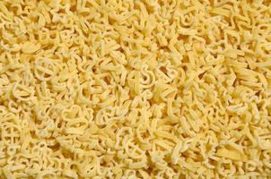 Texture of a lot of curly raw yellow pasta photo