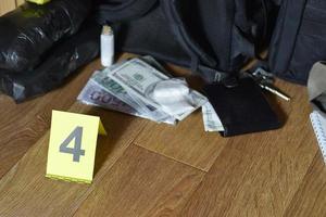 Big heroin packets and packs of money bills as evidence in crime scene investigation process photo