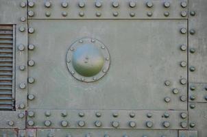 The texture of the wall of the tank, made of metal and reinforced with a multitude of bolts and rivets. Images of the covering of a combat vehicle from the Second World War photo