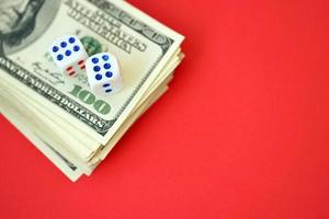 Money, finance and gambling concept. Close up on an American hundred US dollar banknotes and two white dice on top showing the numbers six photo