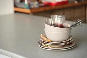 Stack of dirty dishes with food leftovers on the table after meal. Banquet ending concept. Unwashed dishes photo