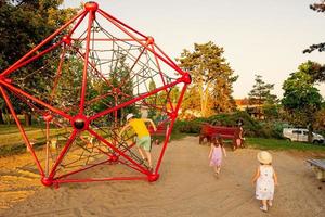 Kids play in rope polyhedron climb at playground outdoor. photo