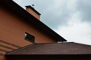 The house is equipped with high-quality roofing of shingles bitumen tiles. A good example of perfect roofing. The roof is reliably protected from adverse weather conditions photo