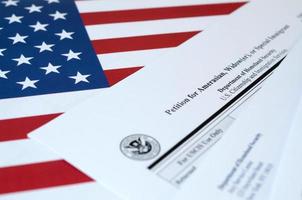 I-360 Petition for Amerasian, Widower or special immigrant blank form lies on United States flag with envelope from Department of Homeland Security photo