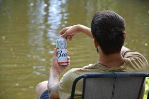 KHARKOV, UKRAINE - JULY 2, 2021 Man holds Budweiser Lager Alcohol Beer during fishing. Budweiser is Brand from Anheuser-Busch Inbev most popular in America photo