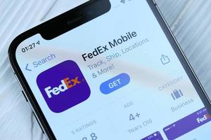 KHARKOV, UKRAINE - MARCH 5, 2021 Fedex icon and application from App store on iPhone 12 pro display screen on white table photo