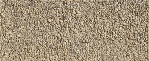 Texture of a stone wall with small round pebble stones. Part of a stone wall as a background or texture photo
