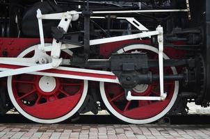 Red wheels of steam train photo