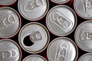 Many cans of soda soft drink or energy drink containers. A lot of recycled cans made from aluminum and being prepared for re-production. photo