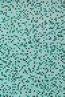 The texture of the wall, decorated with a mosaic of various small square tiles. Abstract pattern of ceramic tiles on the wall photo