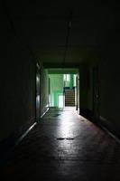 The gloomy corridor of a neglected public building. Public space in a poor residential high-rise building photo