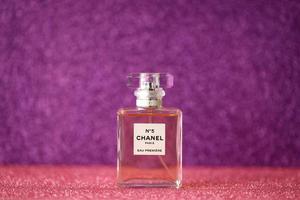 ternopil, ucrania - 2 de septiembre de 2022 chanel número 5 eau estreno mundialmente famoso frasco de perfume francés sobre fondo brillante en colores púrpura foto