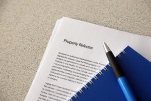 Property release blank form with blue notepad and blue pen lies on photographers table. Property release signing photo