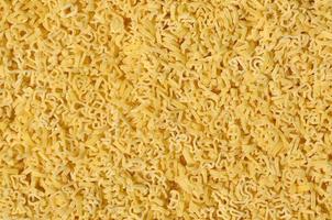 Texture of a lot of curly raw yellow pasta photo