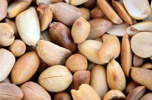 Peanut. A lot of small yellow nuts without peel. Background texture photo