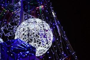 fragmento del árbol de año nuevo. muchas luces redondas de color azul están ubicadas en un marco cónico foto