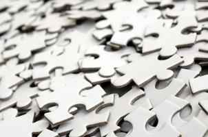 Close-up of a pile of uncompleted elements of a white puzzle. A huge number of rectangular pieces from one large white mosaic photo