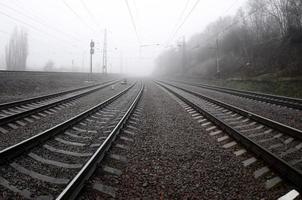 The railway track in a misty morning. A lot of rails and sleepers go into the misty horizon. Fisheye photo with increased distortion