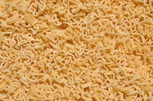 Texture of a lot of curly raw yellow pasta photo