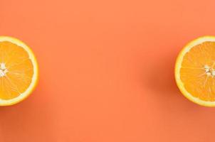 Top view of a several orange fruit slices on bright background in orange color. A saturated citrus texture image photo