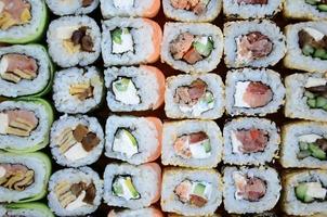 Close-up of a lot of sushi rolls with different fillings. Macro shot of cooked classic Japanese food. Background image photo