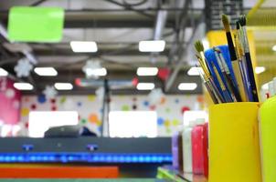 Art paint brushes in cup are located in the children's entertainment hall photo