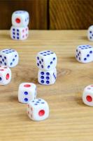 A few dice lies on the surface of natural wood. Items for generating numbers from one to six in the form of points that are painted on the side of cubes. The concept of gambling photo