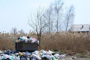 el bote de basura está lleno de basura y desechos. retiro intempestivo de basura en zonas pobladas foto