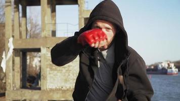 un gars d'apparence caucasienne un boxeur en gants rouges fait un exercice de combat avec une ombre à la caméra. ralenti. vidéo de motivation. video
