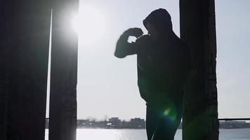 Silhouette of a boxer on a sunset background. Coaches punches. Shadow-boxing. Outdoor workout. Motivational video. Theme of healthy lifestyle and sport. Martial arts. Boxing. Slow motion. video