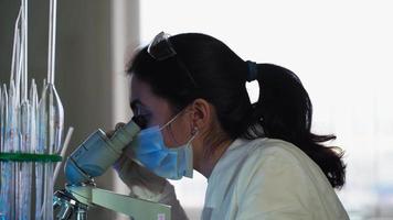 Female Microbiologist Looking into Microscope in Medical Science Laboratory. Scientist, Working with High-Tech Equipment. Pharmaceutical Medicine, Biochemistry, Science Concept. video