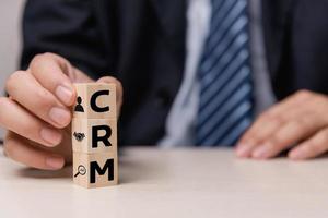 Wooden cubes with CRM Customer relationship management automation system software symbol on desk and copy space.Business concepts. photo