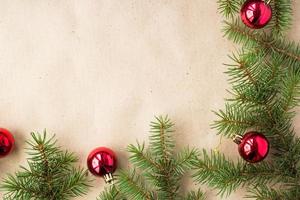 Fir tree branches decorated with red christmas balls as border on a rustic holiday background frame with copy space photo