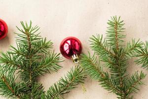 Fir tree branches decorated with red christmas balls as border on a rustic holiday background frame with copy space photo
