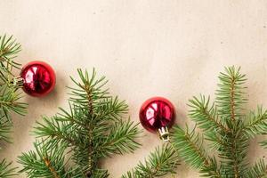 Fir tree branches decorated with red christmas balls as border on a rustic holiday background frame with copy space photo