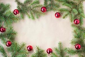 Fir tree branches decorated with red christmas balls as border on a rustic holiday background frame with copy space photo