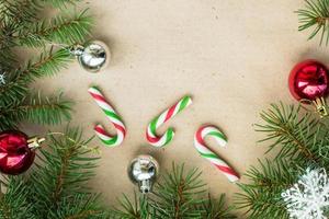 Festive christmas border with red and silver balls on fir branches and snowflakes on rustic beige background photo