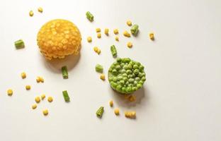 Frozen vegetables close-up on a white background Frozen corn, green peas, chopped green beans. Copy space photo